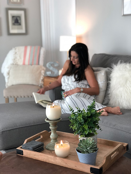 Image for monthly media and management program - woman on couch with candles on table